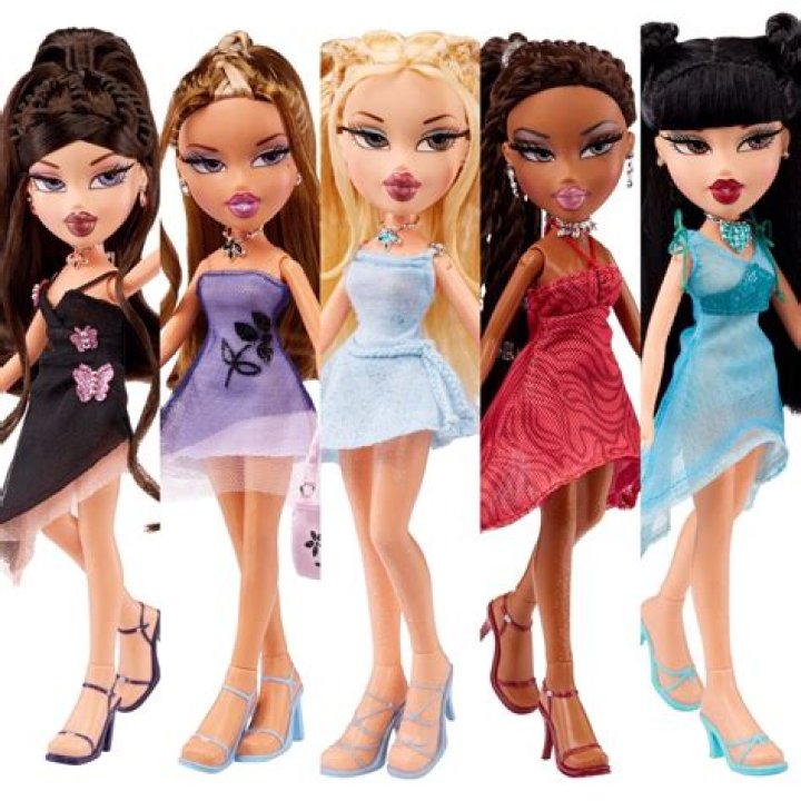 The Bratz dolls are posing against a purple background. 